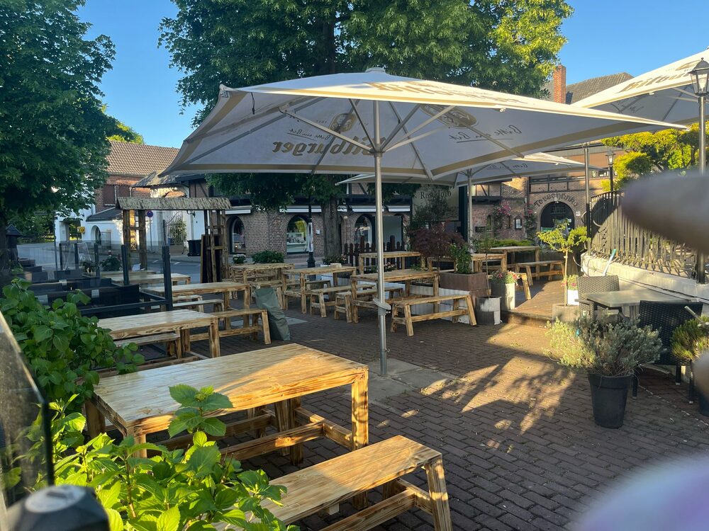 Sonnenschirme und Holztische auf der Außenterrasse